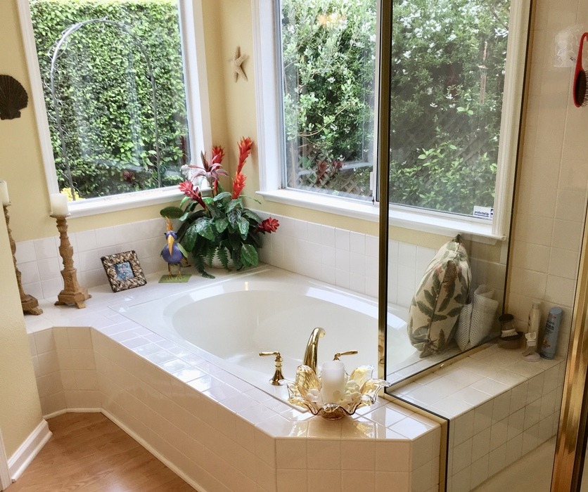 Corner soaking tub with dated tile before remodeling