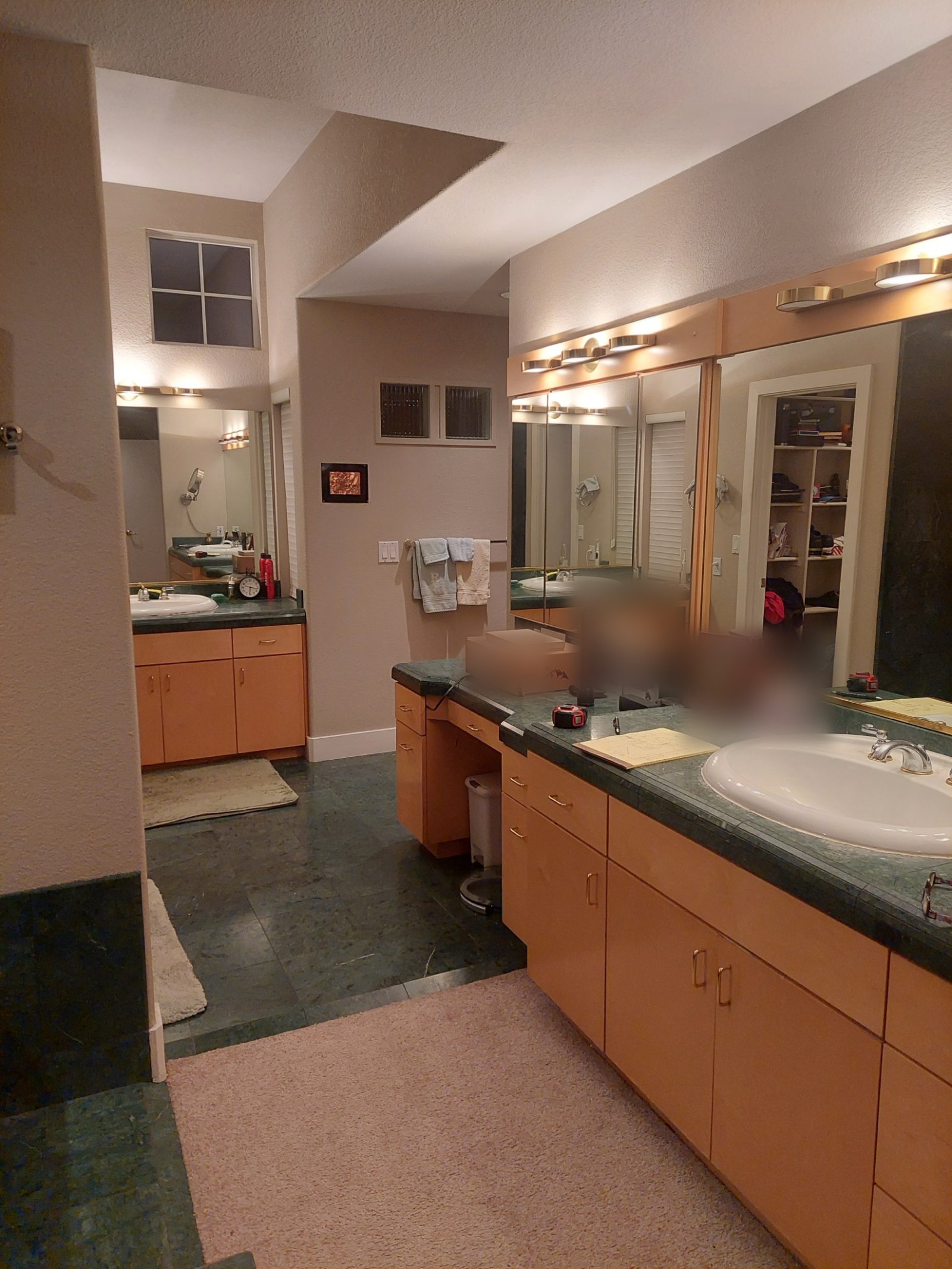 Original master bathroom with maple cabinets, green marble counters and a mirrored vanity wall