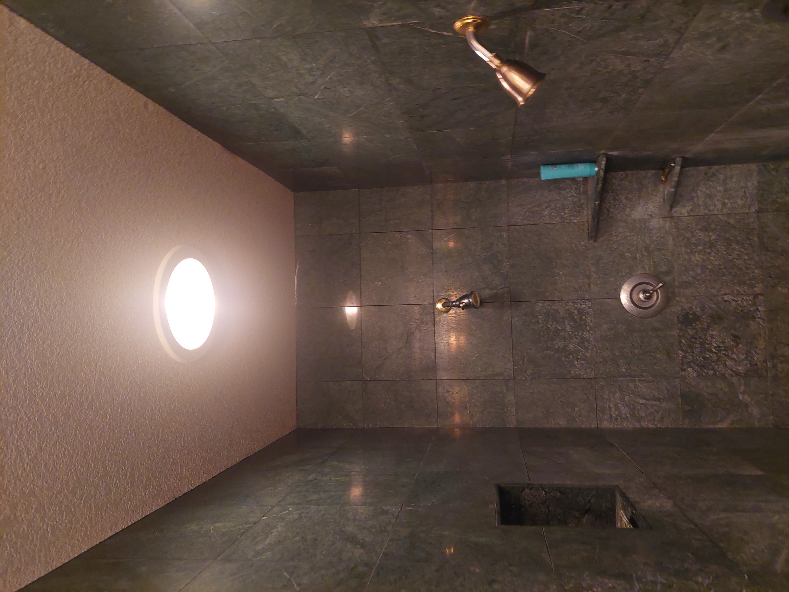 Original dark green marble shower stall with brass fixtures